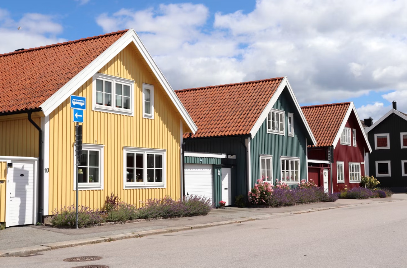 Gula, gröna och röda trähus längs en svensk gata